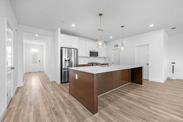 2062 N Osmun Ave, Clovis, CA 93619 - kitchen with stainless steel appliances, light wood-type flooring, light countertops, white cabinets, and recessed lighting