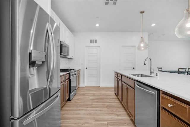 2062 N Osmun Ave, Clovis, CA 93619 - kitchen with stainless steel appliances, light wood finished floors, hanging light fixtures, recessed lighting, and decorative backsplash