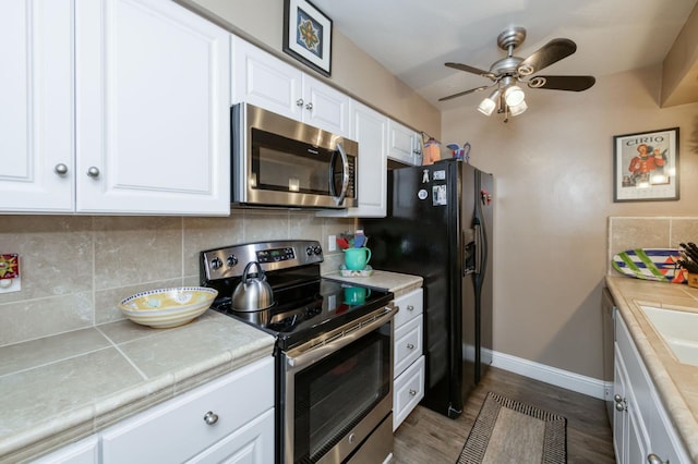 5090 N College Ave Unit 103, Fresno, CA 93704 - kitchen featuring stainless steel appliances, tile counters, backsplash, white cabinetry, and a ceiling fan
