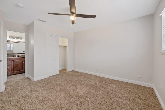 3012 W Santa Ana Ave, Fresno, CA 93722 - unfurnished bedroom featuring light carpet, a closet, ceiling fan, and connected bathroom