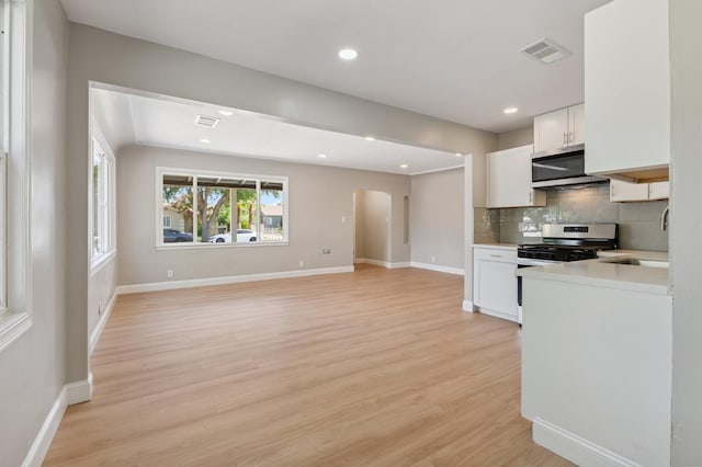 4545 E Grant Ave, Fresno, CA 93702 - kitchen with stainless steel appliances, arched walkways, light countertops, light wood-type flooring, and tasteful backsplash