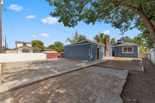 4545 E Grant Ave, Fresno, CA 93702 - back of house featuring a gate, a chimney, a patio, and roof with shingles