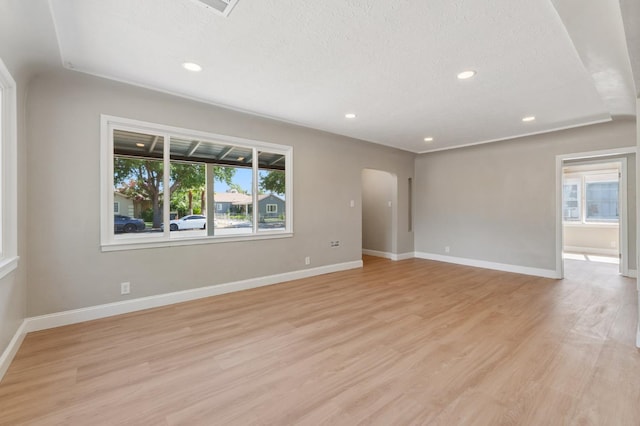 4545 E Grant Ave, Fresno, CA 93702 - empty room featuring a textured ceiling, light wood-style floors, recessed lighting, and arched walkways