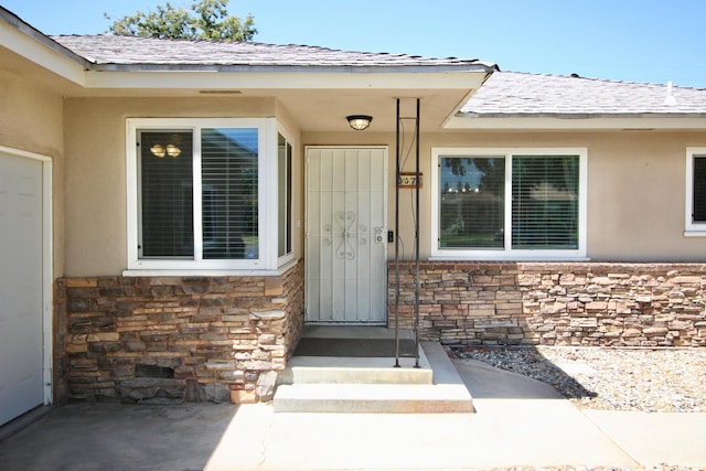 3377 E Richert Ave, Fresno, CA 93726 - property entrance featuring stone siding, stucco siding, and roof with shingles