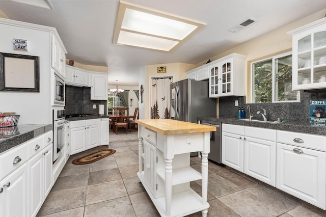 40416 Wild Rose Ln, Shaver Lake, CA 93664 - kitchen featuring stainless steel appliances, open shelves, tile countertops, and white cabinets