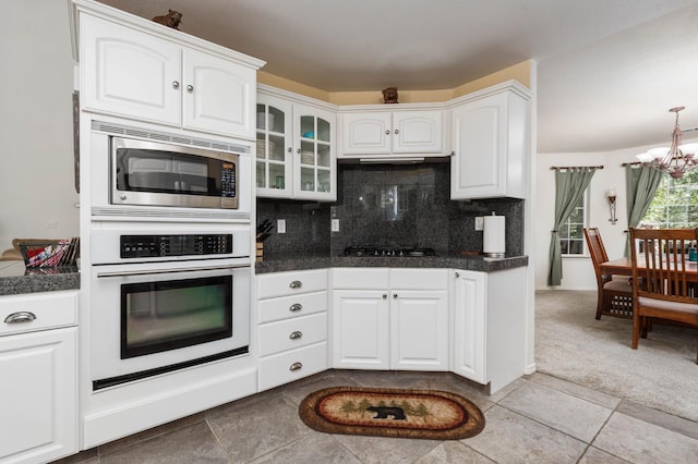 40416 Wild Rose Ln, Shaver Lake, CA 93664 - kitchen featuring appliances with stainless steel finishes, a chandelier, white cabinetry, tasteful backsplash, and glass insert cabinets
