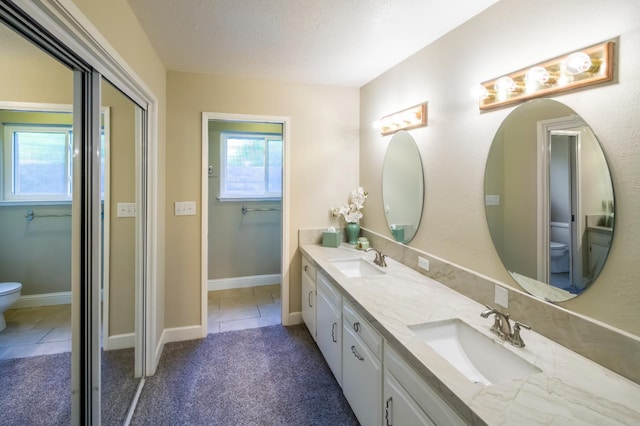 2805 W Spruce Ave, Fresno, CA 93711 - bathroom with double vanity, tile patterned flooring, and a textured ceiling