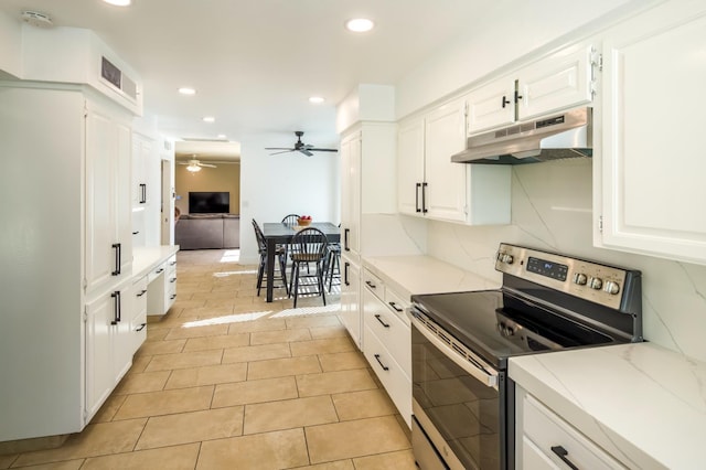 2805 W Spruce Ave, Fresno, CA 93711 - kitchen with stainless steel range with electric cooktop, under cabinet range hood, white cabinets, ceiling fan, and light stone counters