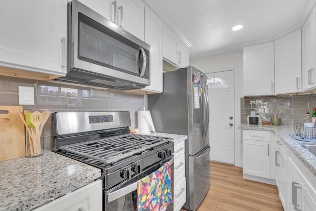 1383 N Safford Ave, Fresno, CA 93728 - kitchen with stainless steel appliances, decorative backsplash, white cabinetry, light wood finished floors, and recessed lighting