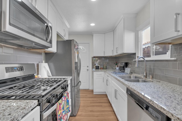 1383 N Safford Ave, Fresno, CA 93728 - kitchen with appliances with stainless steel finishes, light wood finished floors, white cabinetry, and recessed lighting