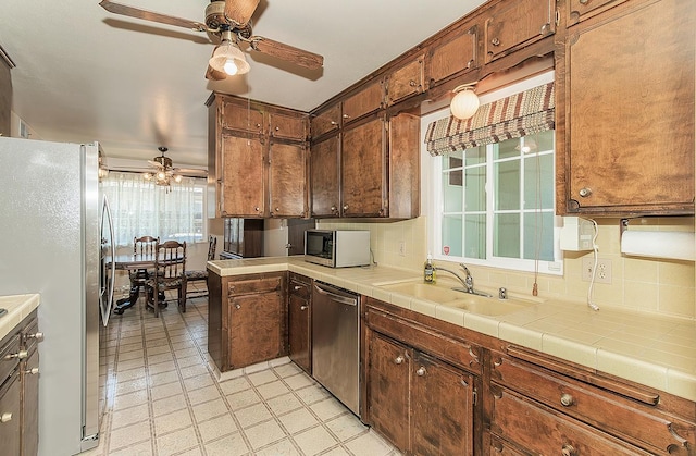 4368 N Hughes Ave, Fresno, CA 93705 - kitchen featuring appliances with stainless steel finishes, a ceiling fan, and decorative backsplash