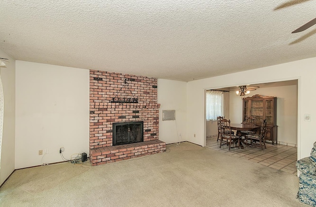4368 N Hughes Ave, Fresno, CA 93705 - carpeted living area featuring a ceiling fan, a brick fireplace, a textured ceiling, and tile patterned floors