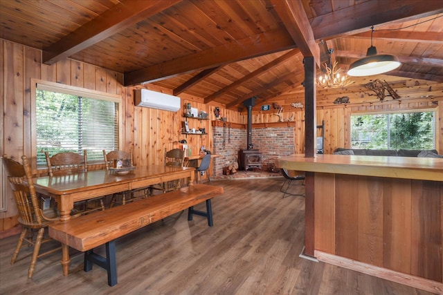 44800 Mountain Meadow Rd, Oakhurst, CA 93644 - dining room with a wall mounted AC, wooden ceiling, wooden walls, a wood stove, and wood finished floors
