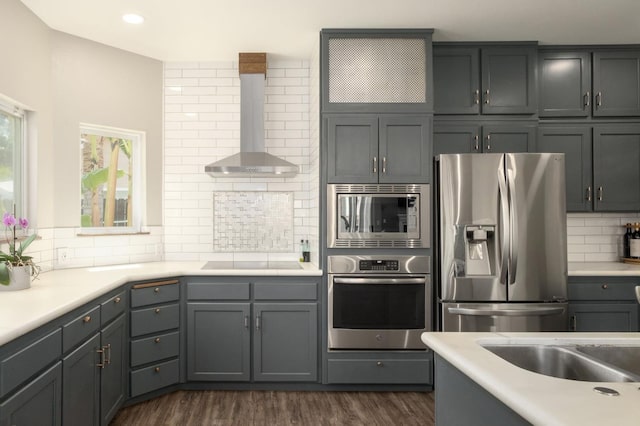 632 W Palo Alto Ave, Clovis, CA 93612 - kitchen featuring stainless steel appliances, wall chimney exhaust hood, decorative backsplash, dark wood-type flooring, and light countertops