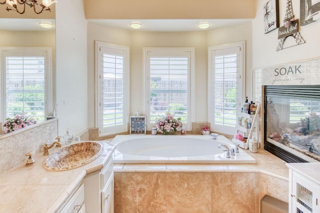 212 W Everglade Ave, Clovis, CA 93619 - full bathroom featuring a bath, vanity, a premium fireplace, and a chandelier