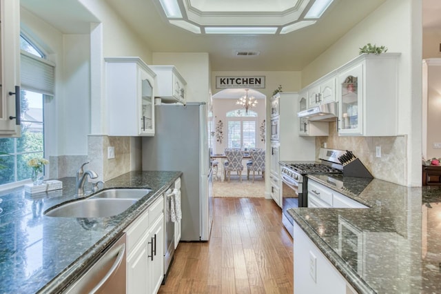 212 W Everglade Ave, Clovis, CA 93619 - kitchen with appliances with stainless steel finishes, under cabinet range hood, white cabinetry, and arched walkways