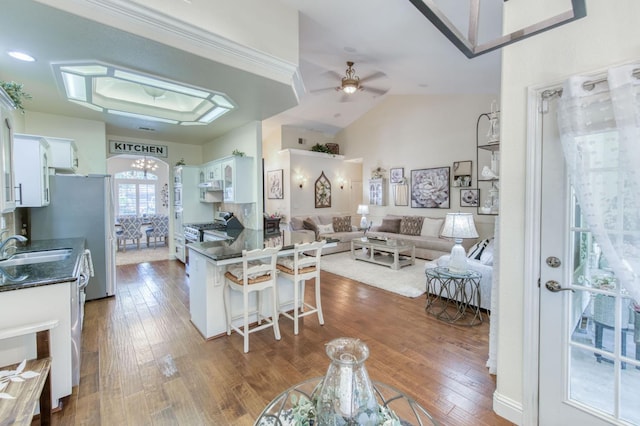 212 W Everglade Ave, Clovis, CA 93619 - kitchen with dark countertops, white cabinetry, appliances with stainless steel finishes, a kitchen breakfast bar, and a ceiling fan