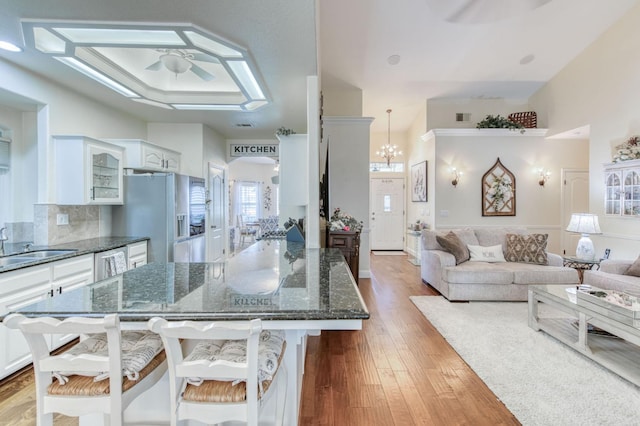 212 W Everglade Ave, Clovis, CA 93619 - kitchen featuring a ceiling fan, stainless steel appliances, a breakfast bar area, and white cabinets