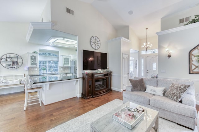 212 W Everglade Ave, Clovis, CA 93619 - living area with high vaulted ceiling, healthy amount of natural light, a chandelier, and wood finished floors