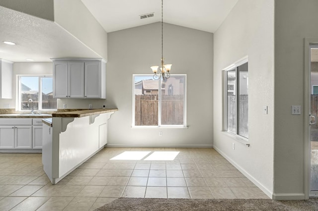 840 Morris Ln, Madera, CA 93637 - kitchen with a kitchen breakfast bar, a chandelier, light tile patterned floors, pendant lighting, and a peninsula
