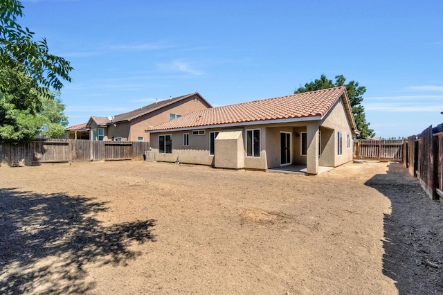 840 Morris Ln, Madera, CA 93637 - rear view of house with stucco siding, a tile roof, and a fenced backyard