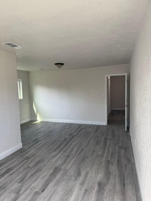 3922 E Lyell Ave, Fresno, CA 93702 - empty room featuring dark wood finished floors and a textured ceiling