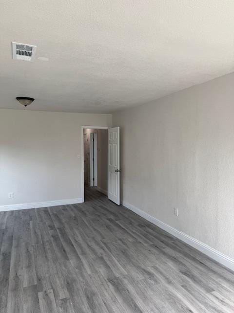 3922 E Lyell Ave, Fresno, CA 93702 - empty room with dark wood finished floors and a textured ceiling