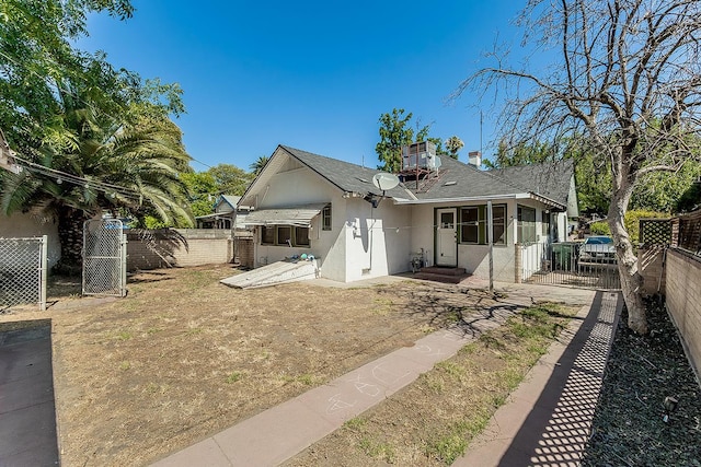 4430 E Iowa Ave, Fresno, CA 93702 - back of house with stucco siding, a fenced backyard, roof with shingles, and a gate