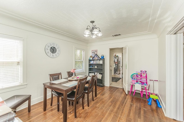 4430 E Iowa Ave, Fresno, CA 93702 - dining area featuring a chandelier, wood finished floors, and a textured ceiling