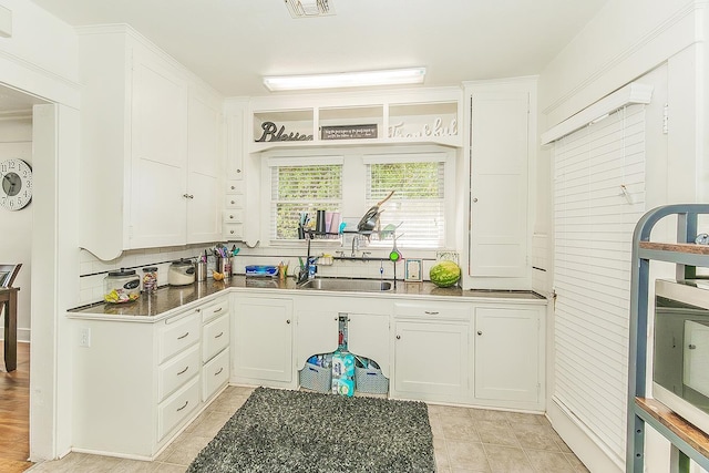 4430 E Iowa Ave, Fresno, CA 93702 - kitchen featuring white cabinetry, backsplash, and light tile patterned floors
