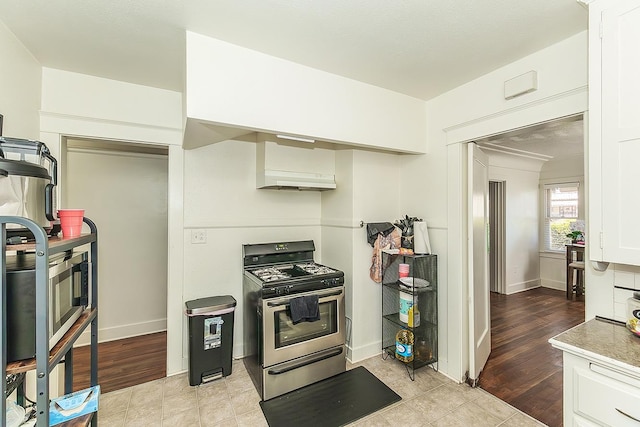 4430 E Iowa Ave, Fresno, CA 93702 - kitchen with stainless steel gas range, white cabinets, range hood, and light countertops