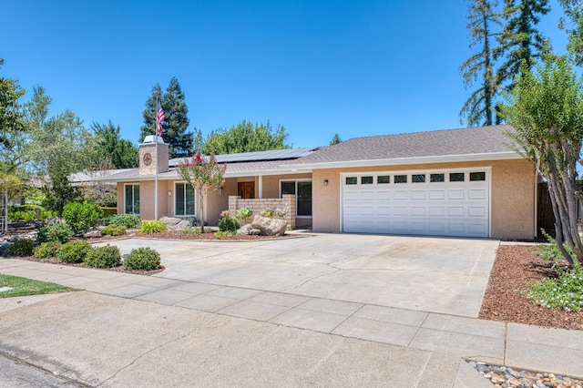 3348 W Sierra Ave, Fresno, CA 93711 - ranch-style house featuring an attached garage, solar panels, driveway, and stucco siding