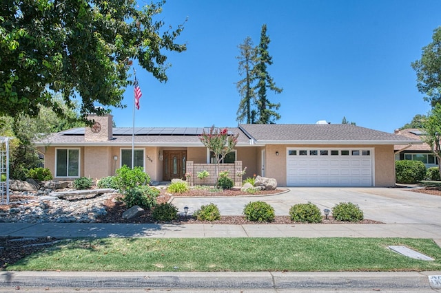 3348 W Sierra Ave, Fresno, CA 93711 - single story home featuring an attached garage, concrete driveway, stucco siding, and roof mounted solar panels