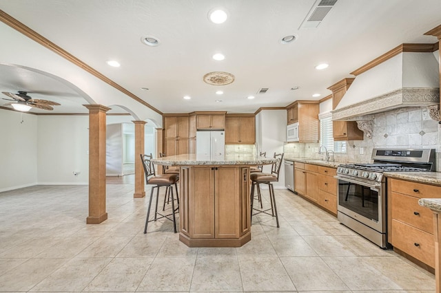 3348 W Sierra Ave, Fresno, CA 93711 - kitchen with stainless steel appliances, ornate columns, ornamental molding, arched walkways, and tasteful backsplash