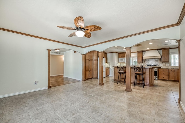 3348 W Sierra Ave, Fresno, CA 93711 - living area featuring a ceiling fan, plenty of natural light, arched walkways, crown molding, and light tile patterned flooring