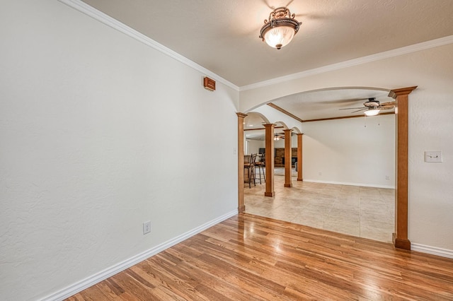 3348 W Sierra Ave, Fresno, CA 93711 - unfurnished room featuring decorative columns, arched walkways, crown molding, ceiling fan, and light wood-style floors