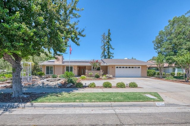3348 W Sierra Ave, Fresno, CA 93711 - single story home featuring an attached garage, driveway, roof mounted solar panels, and stucco siding