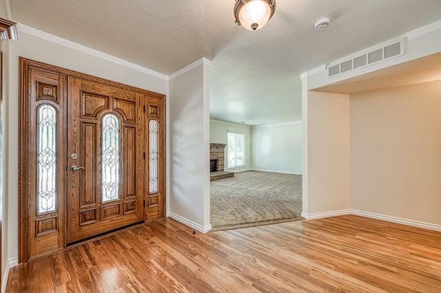 3348 W Sierra Ave, Fresno, CA 93711 - foyer entrance featuring light wood-style floors, ornamental molding, and a fireplace