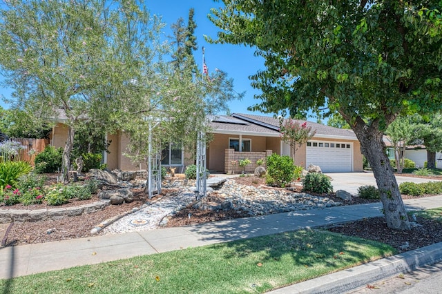 3348 W Sierra Ave, Fresno, CA 93711 - view of front of property featuring an attached garage, roof mounted solar panels, concrete driveway, a porch, and stucco siding