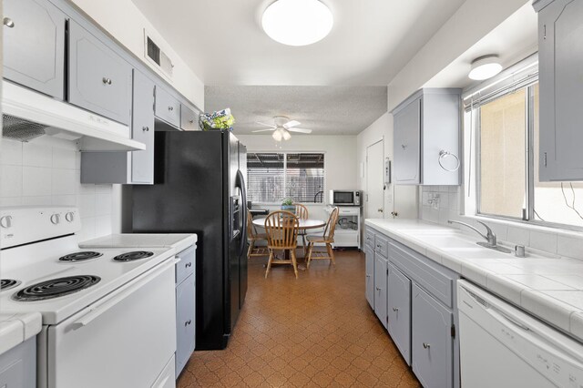 1446 Pico Ave, Clovis, CA 93611 - kitchen featuring white appliances, under cabinet range hood, a ceiling fan, tile patterned floors, and decorative backsplash