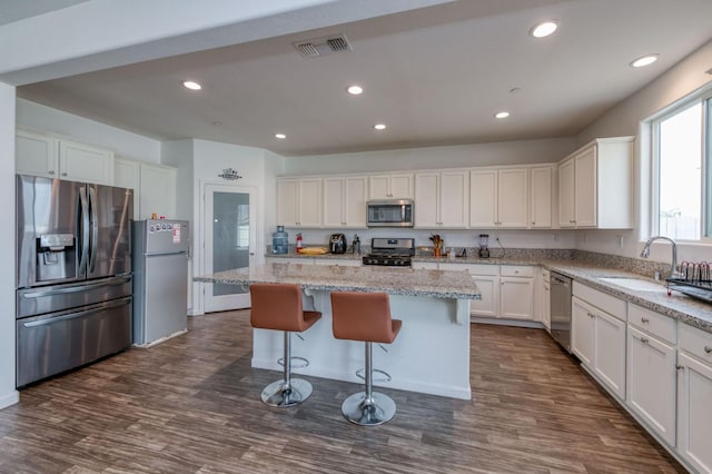 14288 W El Mar Ave, Kerman, CA 93630 - kitchen featuring appliances with stainless steel finishes, white cabinetry, dark wood finished floors, a center island, and recessed lighting