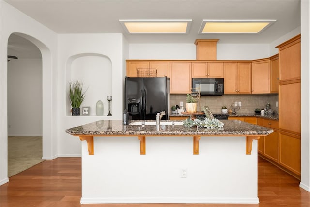 1935 N Glen Alva Ln, Clovis, CA 93619 - kitchen with black appliances, an island with sink, a kitchen bar, and dark stone counters