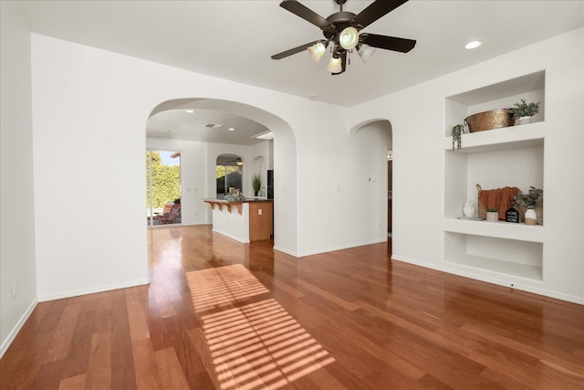 1935 N Glen Alva Ln, Clovis, CA 93619 - unfurnished living room featuring built in shelves, wood finished floors, ceiling fan, recessed lighting, and arched walkways