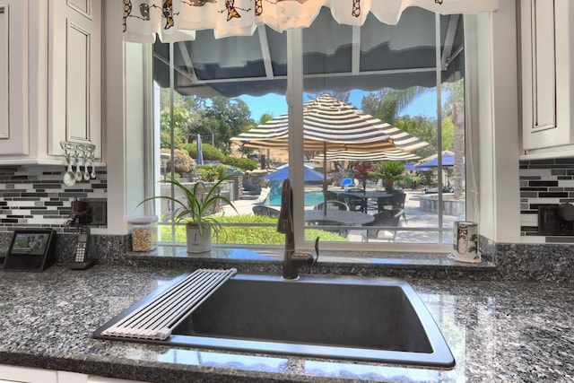 43295 Running Deer Dr, Coarsegold, CA 93614 - kitchen view of tasteful backsplash, white cabinetry, and dark stone countertops