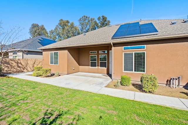 7399 N Riverside Dr, Fresno, CA 93722 - rear view of property with roof mounted solar panels, stucco siding, a patio, and roof with shingles