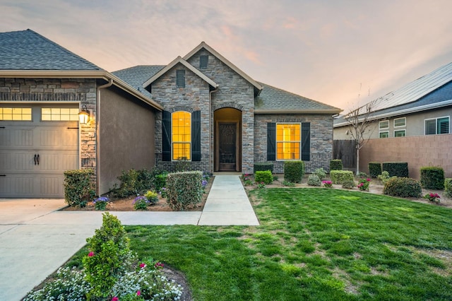 7399 N Riverside Dr, Fresno, CA 93722 - french country home featuring stone siding, a garage, concrete driveway, and roof with shingles
