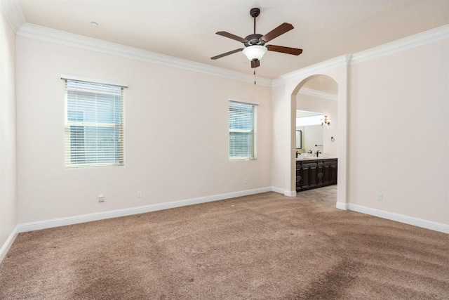 7399 N Riverside Dr, Fresno, CA 93722 - spare room featuring ceiling fan, crown molding, light colored carpet, and arched walkways