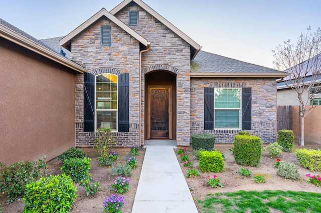7399 N Riverside Dr, Fresno, CA 93722 - property entrance featuring stone siding, stucco siding, and roof with shingles