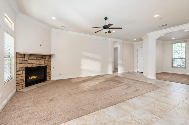 7399 N Riverside Dr, Fresno, CA 93722 - unfurnished living room featuring arched walkways, a ceiling fan, a stone fireplace, ornamental molding, and recessed lighting