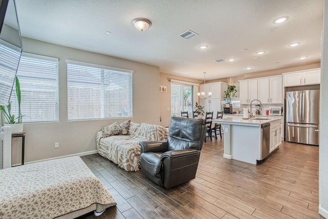 212 Arbor Dr S, Madera, CA 93636 - living room with light wood-style flooring, a chandelier, and recessed lighting